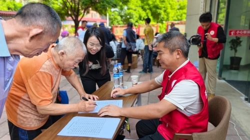 图为2026年7月22日“时光里”志愿服务者为前来拍摄的老人们登记信息